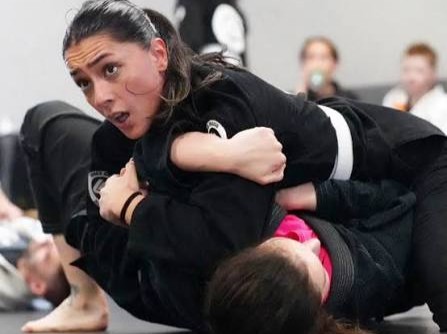Kvinnelig utøver i BJJ-posisjon på matta
